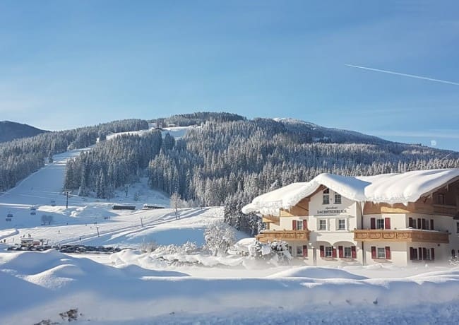Blick auf Aparthotel Dachsteinblick, nahegelegene Skipiste und Skilift Spacejet 1