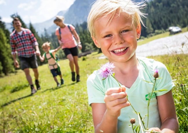 Junge beim Blumen pflücken © Flachau Tourismus